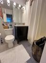 Bathroom featuring tile patterned flooring, vanity, shower / bath combo, and tile walls