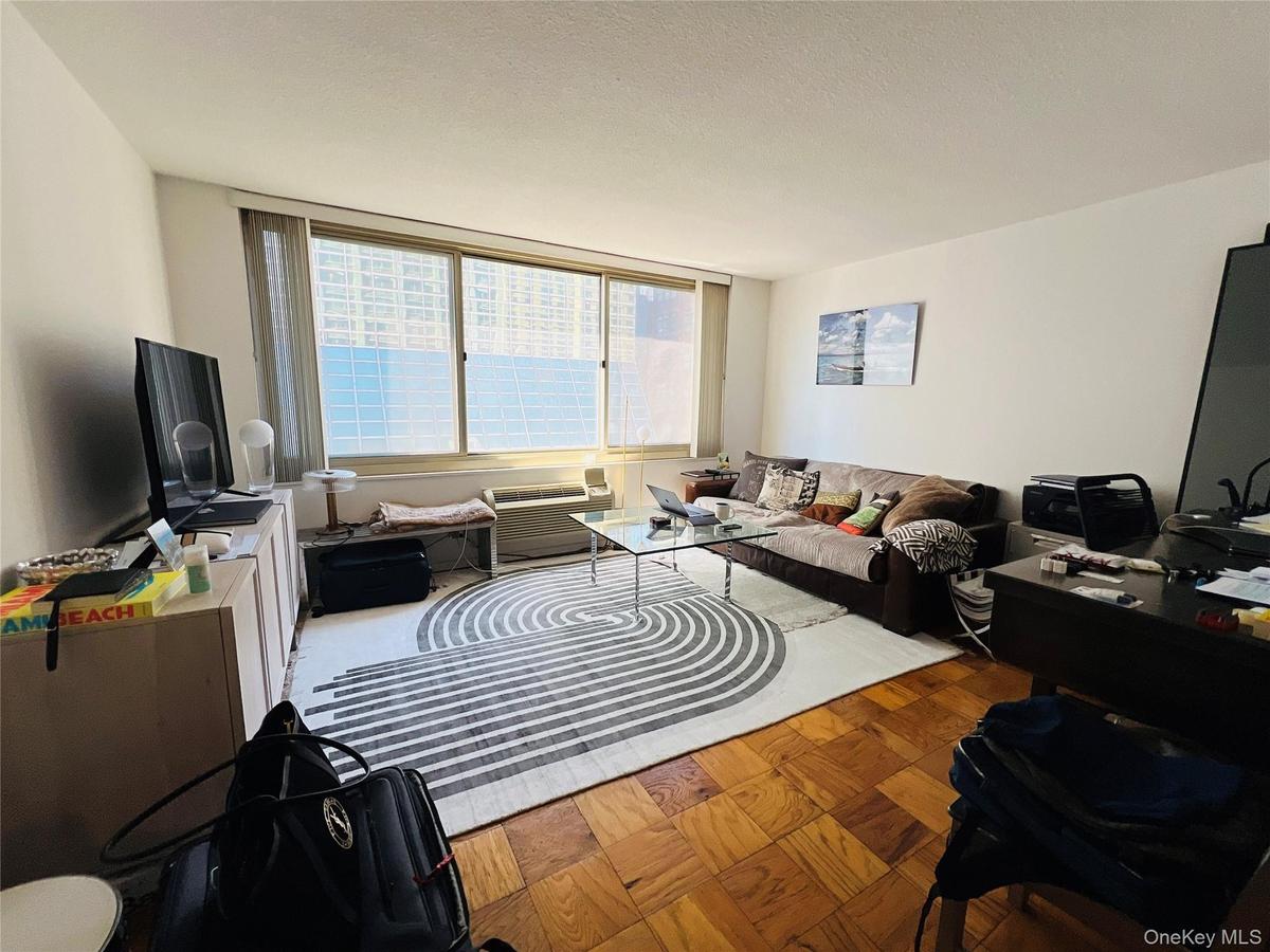 Living room featuring a textured ceiling and a wall unit AC