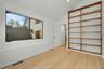 Private office with built-in shelving, large wrap-around windows, and direct access to the primary suite.