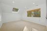 Bedroom 4 with skylight and wooded views.