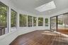 Screened porch with skylight and peaceful woodland views, accessible from the kitchen-dining area and deck.