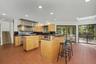 Light-filled kitchen with a center prep island and adjoining dining area with sliding glass doors to the screened-in porch and deck.