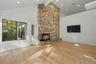 Inviting family room with cathedral ceilings, skylights, and a striking stone fireplace extending to the ceiling.