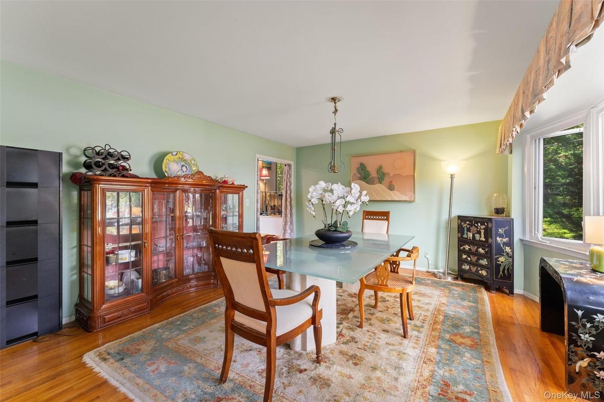 Hardwood flooring, broad window with valance, and a ceiling light fixture.