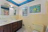 Vanity with two sinks, wood-finish cabinetry, and overhead lighting.