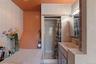 Tiled bathroom featuring a jacuzzi, built-in shower, vanity with sink, and wall-mounted lighting.