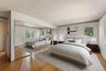 Primary Bedroom is virtually staged. Hardwood flooring, mirrored sliding closet doors, with multiple windows.