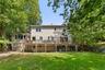 Expansive backyard with a manicured lawn, multi-level wood deck, and mature trees.