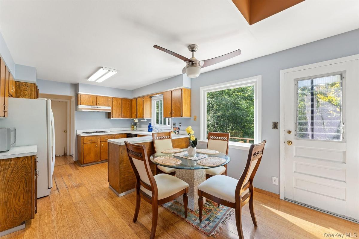 Kitchen featuring wood cabinetry, solid surface countertops, and a ceiling fan.