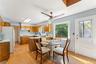Kitchen featuring wood cabinetry, solid surface countertops, and a ceiling fan.
