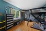 Hardwood flooring with a white ceiling and teal panel walls.
