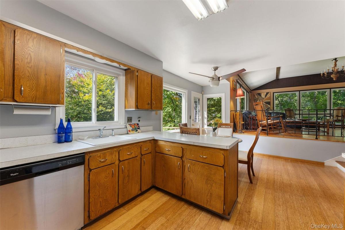 Kitchen featuring wood cabinetry, solid surface countertops, and a ceiling fan.