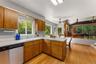 Kitchen featuring wood cabinetry, solid surface countertops, and a ceiling fan.