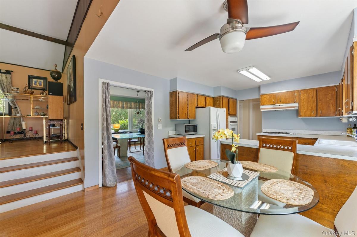 Kitchen featuring wood cabinetry, solid surface countertops, and a ceiling fan.