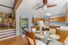 Kitchen featuring wood cabinetry, solid surface countertops, and a ceiling fan.