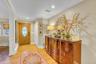 Hardwood flooring, wood entry door with oval leaded glass, white crown molding, recessed lighting, and wall-mounted picture frames