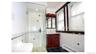 Glass-enclosed shower with white tiled walls