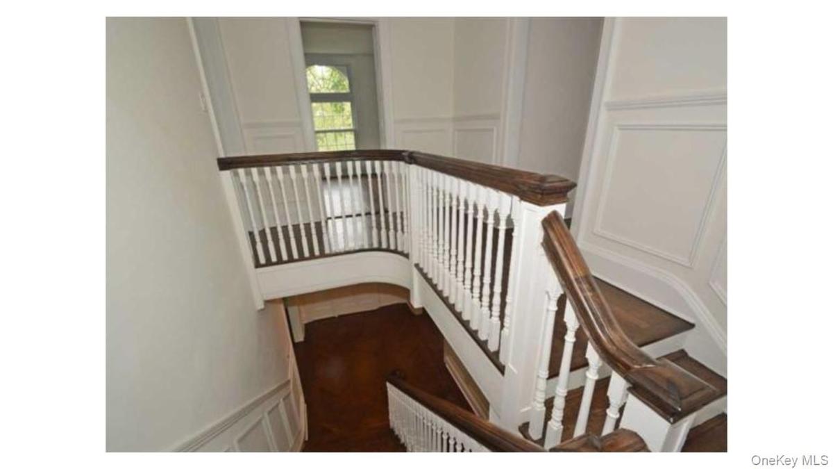 Hardwood stairs with white balusters and dark wood handrails