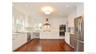 White cabinetry with stainless steel appliances, recessed lighting, wood-finish flooring, and a built-in double oven