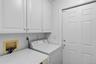 Laundry room with extensive shelving and side-yard access
