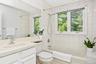Bathroom has sink with vanity and bathtub with shower combo