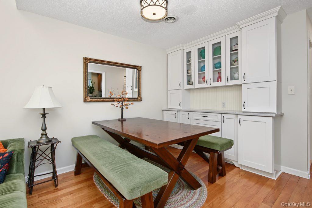 Dining room has hardwood floors and built in wall unit with marble top