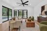 Game room features a wet bar with beverage refrigerator and two large sliding glass doors that provide direct access to pool and covered lanai
