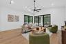 Game room features a wet bar with beverage refrigerator and two large sliding glass doors that provide direct access to pool and covered lanai