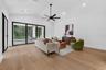 Game room features a wet bar with beverage refrigerator and two large sliding glass doors that provide direct access to pool and covered lanai