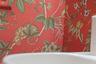 Cheerful patterned wallpaper and a classic pedestal sink bring personality to this bathroom.