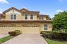 A paver driveway, tropical landscaping, and tile roof give this end-unit home inviting curb appeal.