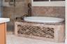 Unwind in the soaking tub, surrounded by rich stone finishes and decorative accents.