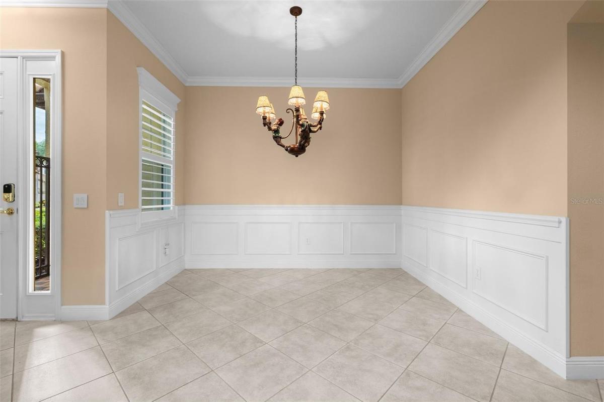 Classic wainscoting and crown molding create a lovely setting for dinners with family and friends.