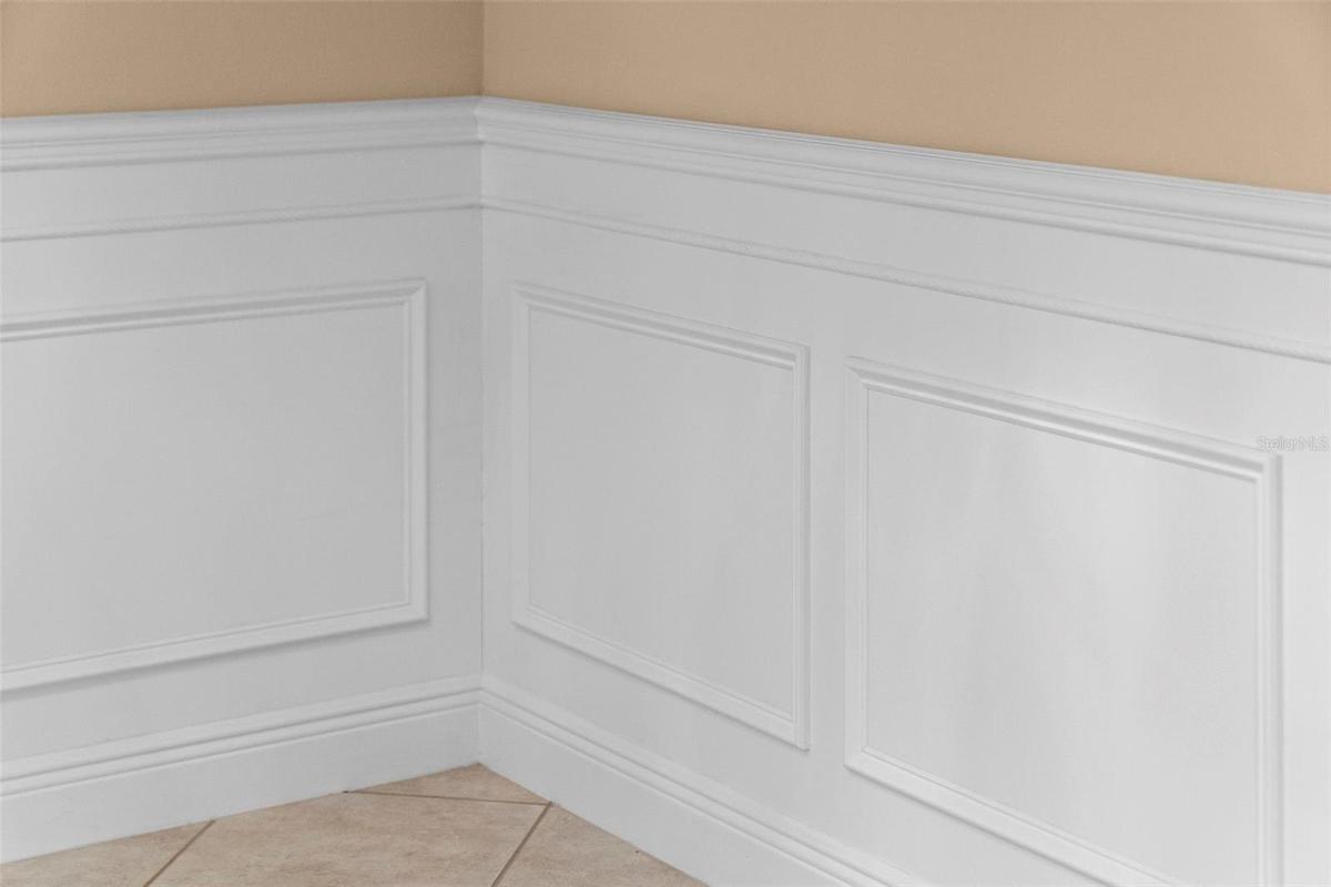 Detailed wainscoting adds timeless charm to the home’s gathering spaces.
