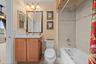 A conveniently arranged guest bath with a tub-and-shower combination and vanity storage.