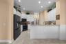 White cabinetry, granite countertops, and a generous breakfast bar make everyday meals and entertaining easy.