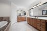 Separate vanities and abundant drawer space make sharing the primary bath easy.