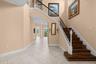 Soaring ceilings and a wood staircase with wrought iron accents make a memorable first impression.