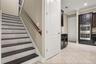 Stairs to 4 bedrooms and 3 bathrooms. To the right of the stairs is the pantry, laundry room and door leading to the 3 car garage
