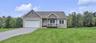 Siding exterior with a covered porch, attached garage, and a paved driveway