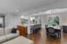 Hardwood-finish flooring throughout, recessed lighting, crown molding, kitchen island with seating, and a decorative chandelier