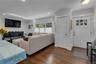 Hardwood-style flooring throughout, recessed lighting, crown molding, and a paneled entry door with decorative glass
