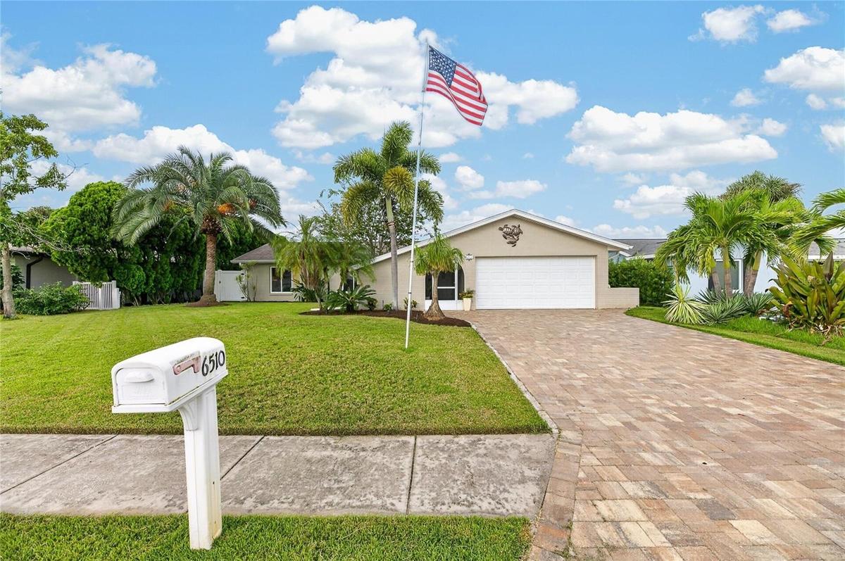 Gorgeous Curb Appeal! Mature manicured landscape, paver driveway, and Zoysia turfgrass!
