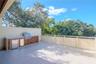 featuring an outdoor kitchen with grill and fridge