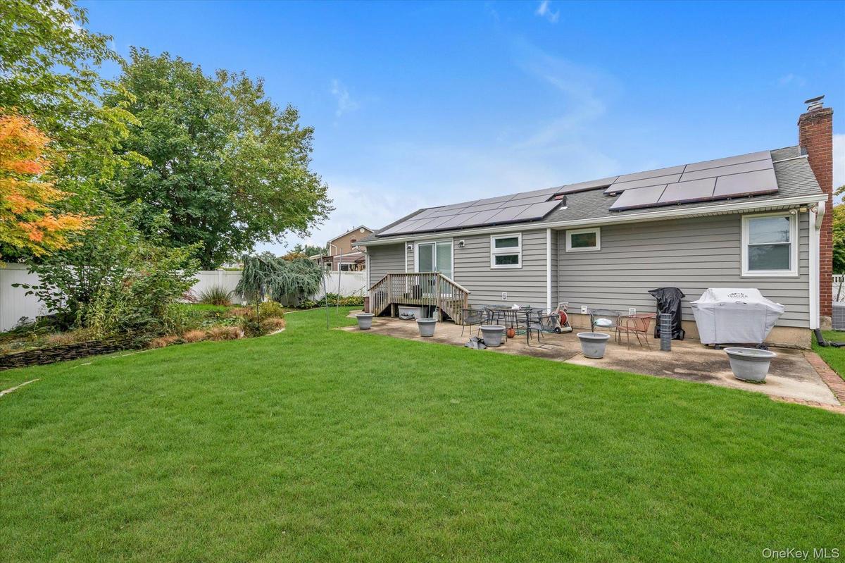 Expansive rear lawn with mature trees and perimeter landscaping