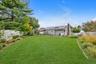 Expansive green lawn with mature perimeter landscaping