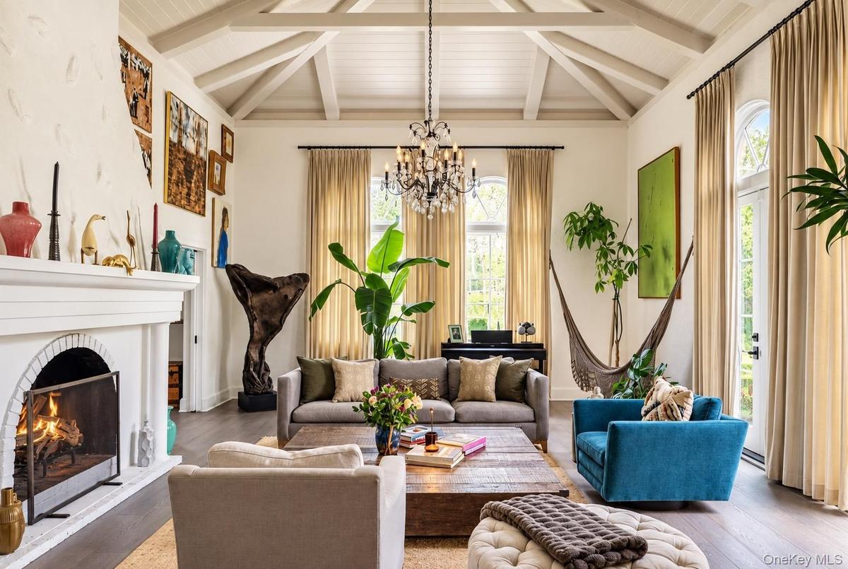 Living room with soaring ceilings, wood burning fireplace and doors to courtyard