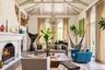 Living room with soaring ceilings, wood burning fireplace and doors to courtyard