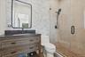 Wood-finish vanity with dark countertop and undermount sink - pool house