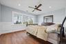 Wood-finish flooring, wainscoting, recessed lighting, ceiling fan, and large windows